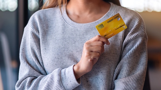 Image en gros plan d'une femme tenant et montrant une carte de crédit