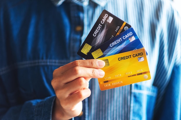 Image en gros plan d'une femme tenant et montrant des cartes de crédit