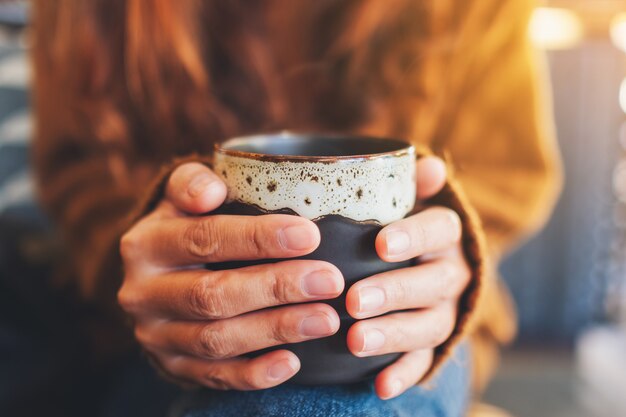 Image gros plan d'une femme tenant une tasse de café chaud