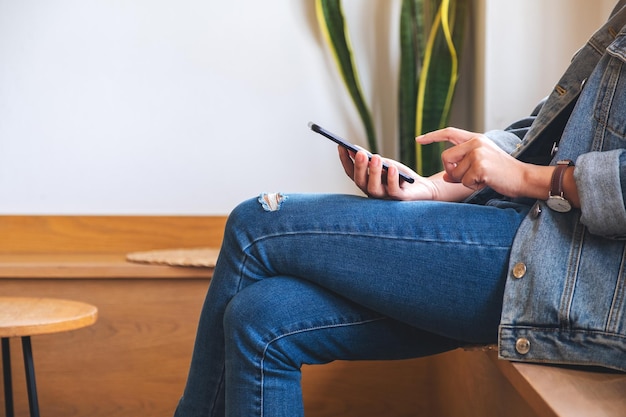 Image en gros plan d'une femme tenant et utilisant un téléphone intelligent