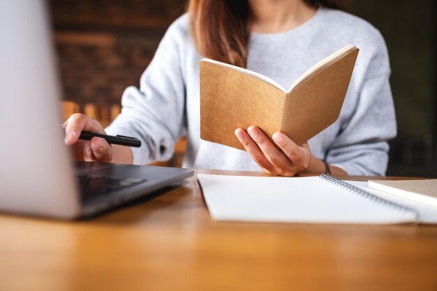 Image en gros plan d'une femme travaillant sur des documents et un ordinateur portable au bureau