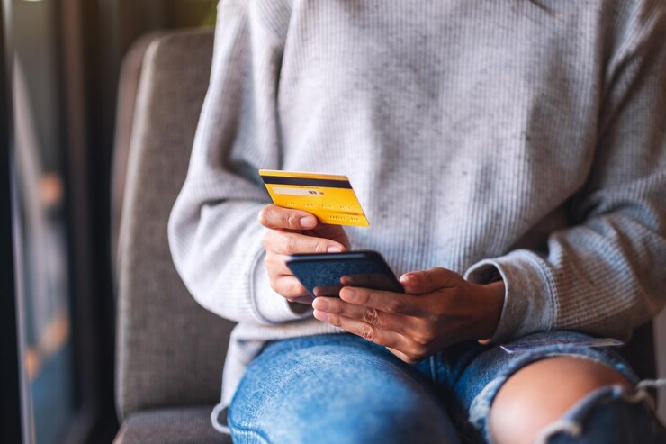 Photo image en gros plan d'une femme utilisant une carte de crédit pour acheter et faire des achats en ligne sur un téléphone mobile