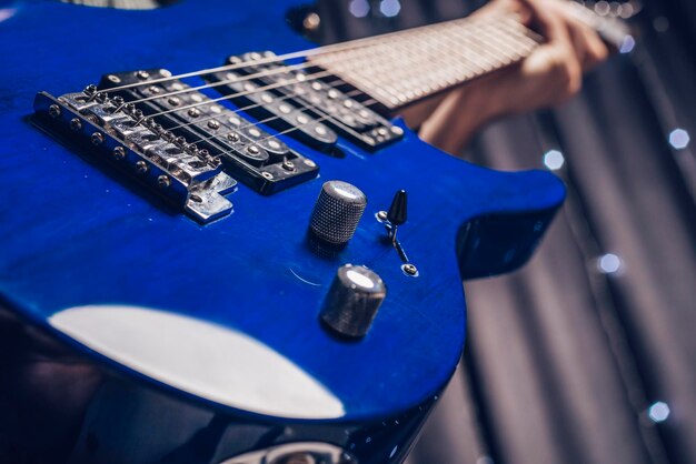 Image en gros plan d'une guitare électrique bleue. Technique mixte