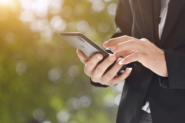 Image Gros plan de l'homme tenant et à l'aide de téléphone portable sur bokeh