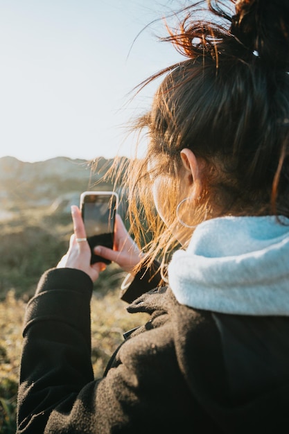 Image en gros plan d'une jeune femme vérifie son téléphone après une journée d'entraînement à l'extérieur Vérification des médias sociaux et publication de nouvelles images à ses fans Prise d'images pour la famille lors d'un voyage avec espace de copie