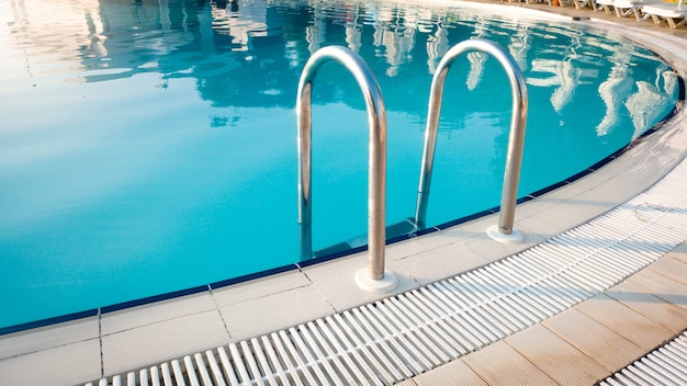 Image gros plan des mains courantes métalliques sur l'escalier à la piscine extérieure