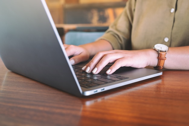 Image Gros plan des mains de la femme à l'aide et en tapant sur le clavier de l'ordinateur portable