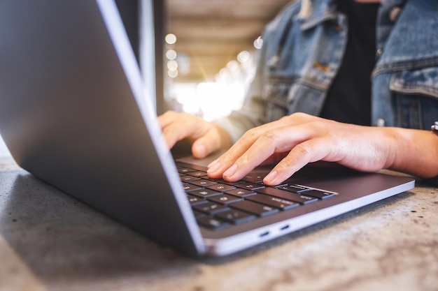 Image en gros plan de mains travaillant et tapant sur le clavier d'un ordinateur portable sur la table