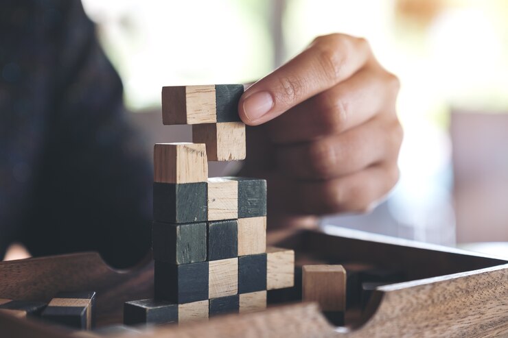 Photo image gros plan de personnes jouant et construisant un jeu de puzzle en bois