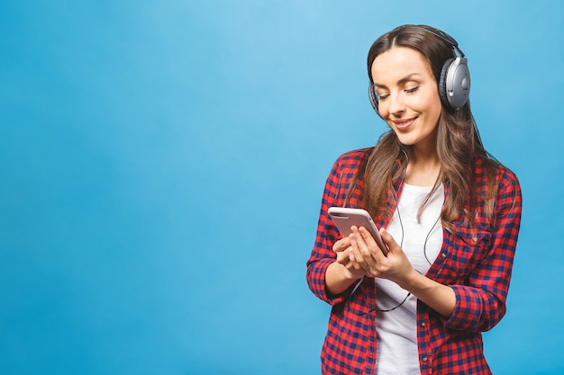 Image de l'heureuse jeune femme écoutant de la musique dans les écouteurs