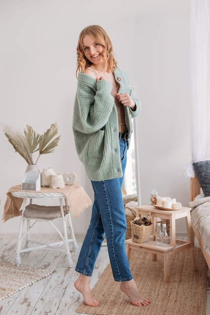 Image de l'heureuse jeune femme posant isolée sur fond de maison.