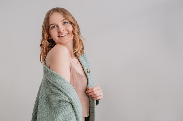 Image de l'heureuse jeune femme posant isolée sur fond de mur gris.