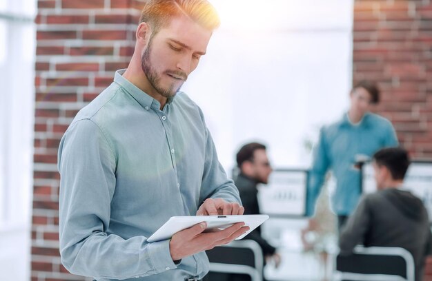 Image d'un homme d'affaires gai travaillant sur une tablette au bureau