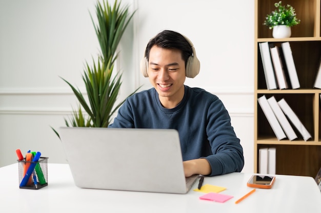 Image d'un homme asiatique assis à la maison travaillant