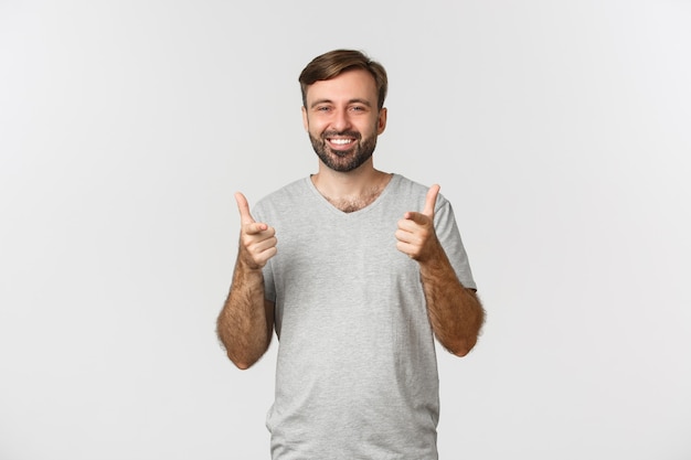 Image d'un homme souriant satisfait en t-shirt gris