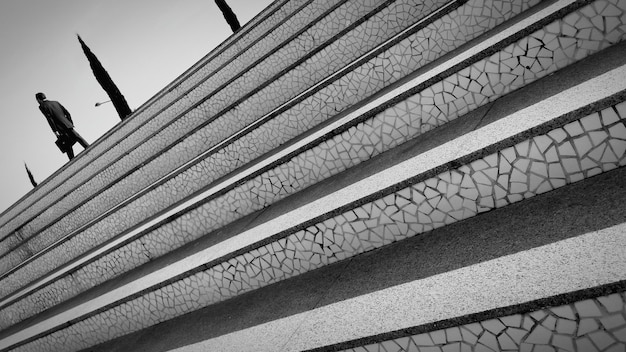 Image inclinée d'un homme marchant dans les escaliers contre un ciel dégagé