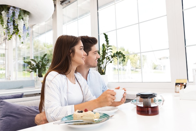 Image De L'incroyable Jeune Couple Amoureux Assis Au Café, Manger Des Desserts Et Boire Du Thé.