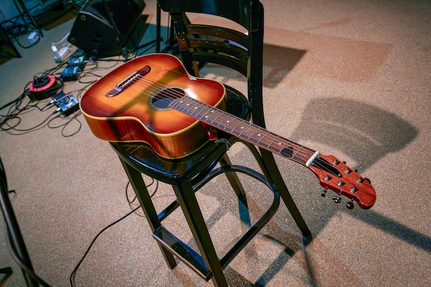 L'image d'un instrument de musique, une guitare acoustique, est posée sur une chaise.