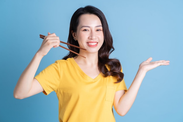 Image d'une jeune femme asiatique tenant une baguette