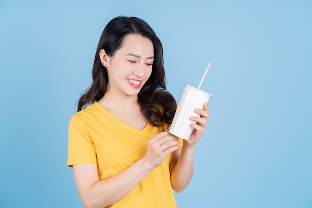 Image d'une jeune femme asiatique tenant une tasse de thé à bulles