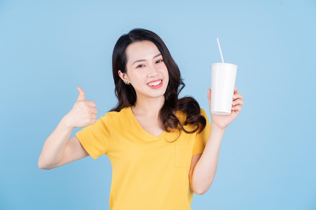 Image d'une jeune femme asiatique tenant une tasse de thé à bulles