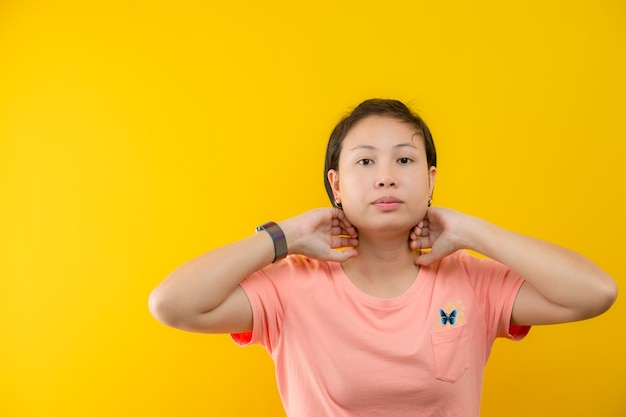 Image d'une jeune femme heureuse debout isolée sur fond jaune. Regarder la caméra.