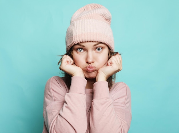 Image d'une jeune femme heureuse portant un chapeau et un pull roses