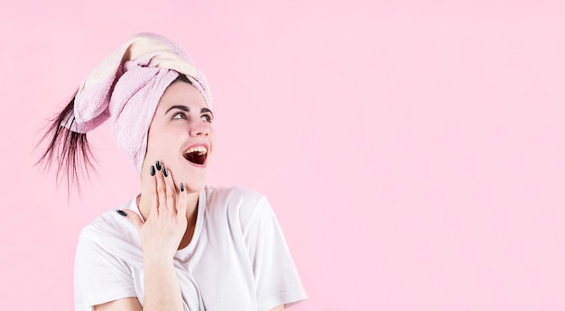 Image de jeune femme hurlant excité debout isolé sur fond rose. Regardant dans le coin supérieur droit.