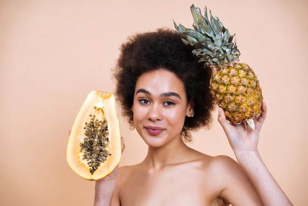 Image d'une jeune femme posant en studio pour une séance photo de concepts positifs du corps. Modèle adolescent montrant des fruits et des aliments sains bons pour la thérapie de soins de la peau