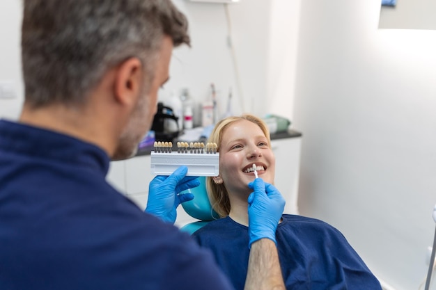 Image d'une jeune femme satisfaite assise dans un fauteuil dentaire au centre médical pendant qu'un médecin professionnel fixait ses dents