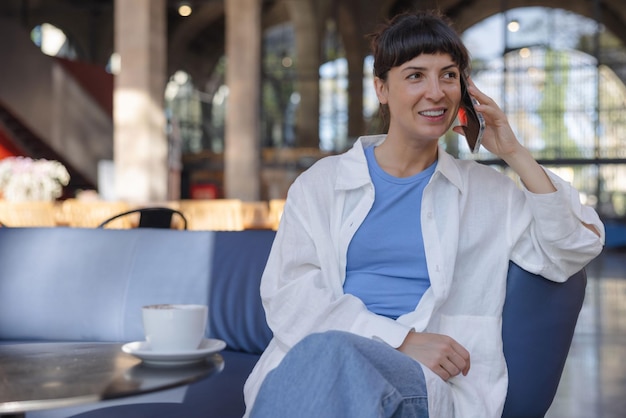 Image d'une jeune femme souriante et parlant au téléphone