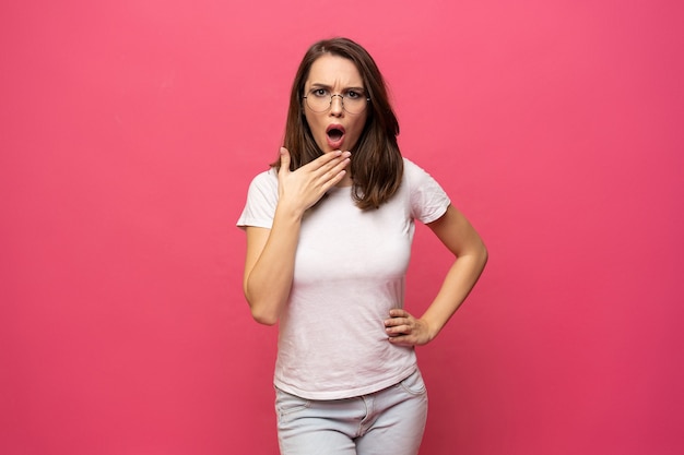 Image de jeune femme surprise debout isolé sur fond rose.