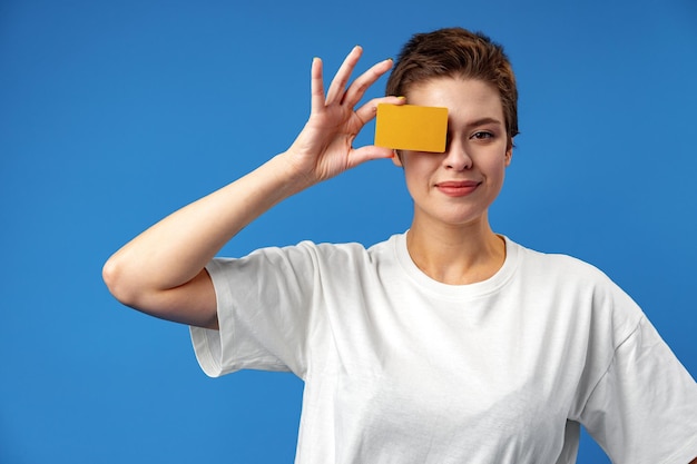 Image de jeune femme tenant une carte de visite avec espace de copie sur fond bleu