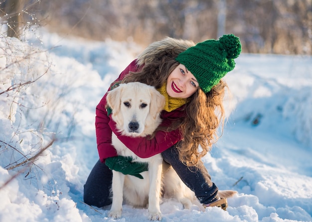 Image De Jeune Fille Avec Son Chien Golden Retriever Blanc étreindre, En Plein Air à L'heure D'hiver