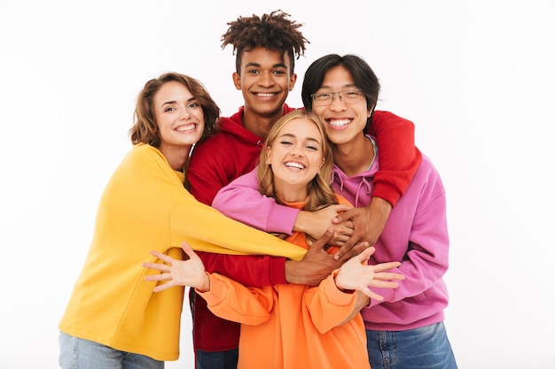 Image d'un jeune groupe d'étudiants amis heureux debout isolé, posant étreindre.