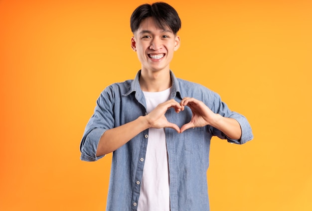 Image de jeune homme asiatique posant sur fond orange