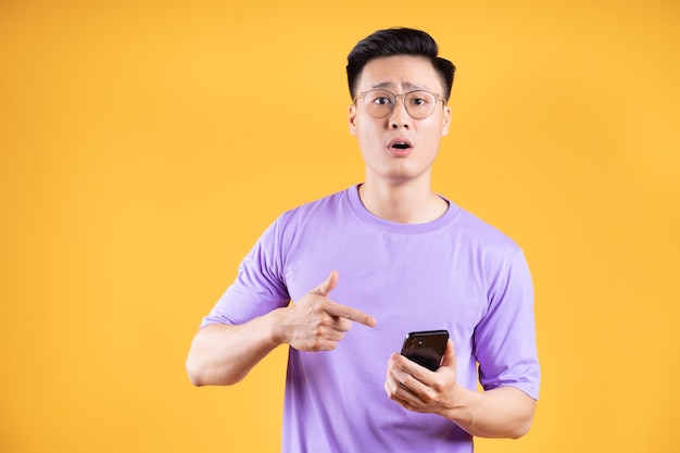 Image d'un jeune homme asiatique utilisant un smartphone en arrière-plan