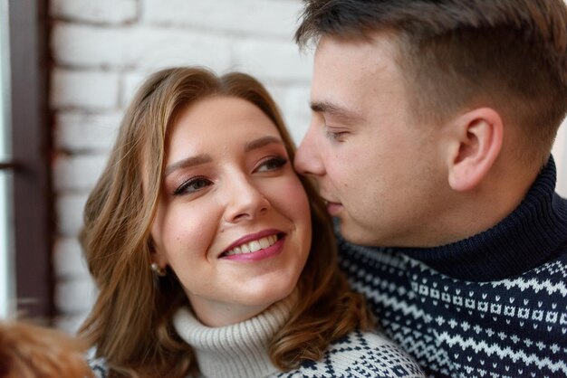 Image d'un jeune homme heureux embrassant et étreignant une belle femme