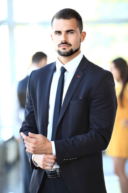 Image de jeunes hommes d'affaires intelligents regardant la caméra lors d'une réunion