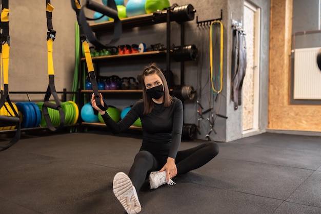 Image d'une jolie femme en forme se reposant et posant dans la salle de sport