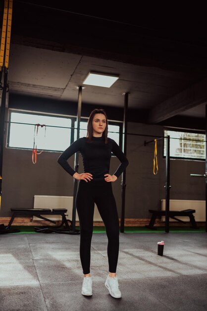 Image d'une jolie femme en forme se reposant et posant dans la salle de sport