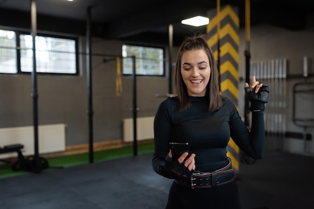 Image d'une jolie femme en forme se reposant et posant dans la salle de sport