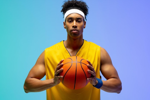 Image d'un joueur de basket-ball biracial avec basket-ball sur fond vert à bleu