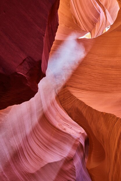 Image de la lumière qui filtre d'en haut et illumine la poussière dans un canyon orange