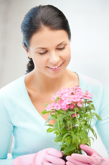 image lumineuse de belle femme au foyer avec fleur en pot