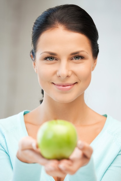 image lumineuse de belle femme au foyer avec pomme verte