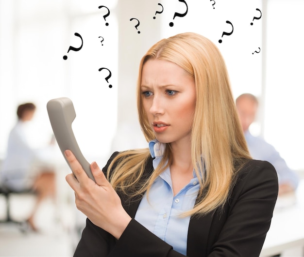 image lumineuse d'une femme confuse avec un téléphone au bureau