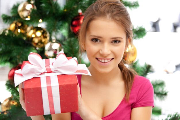 image lumineuse d'une femme heureuse avec une boîte-cadeau et un arbre de noël