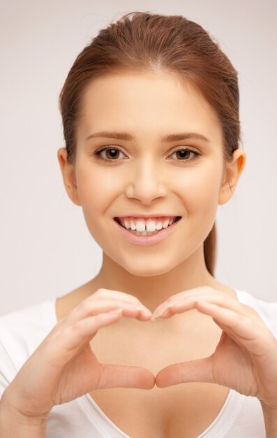 image lumineuse d'une femme heureuse faisant un geste cardiaque