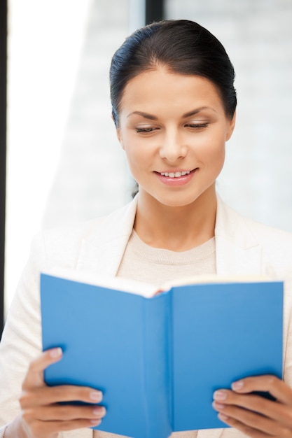 image lumineuse d'une femme heureuse et souriante avec un livre